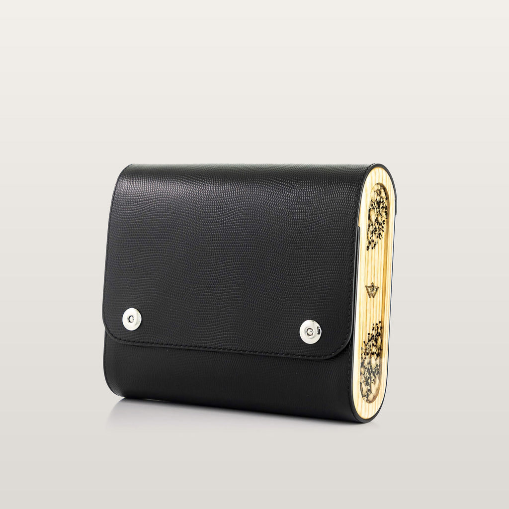Black handbag with gold accents on a light gray background