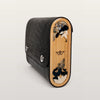 Black textured clutch with wooden side featuring floral designs on a light gray background
