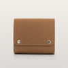 Blizzard cappuccino bag with silver buttons on a light gray background