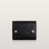 Black leather bag with silver buttons on a light gray background