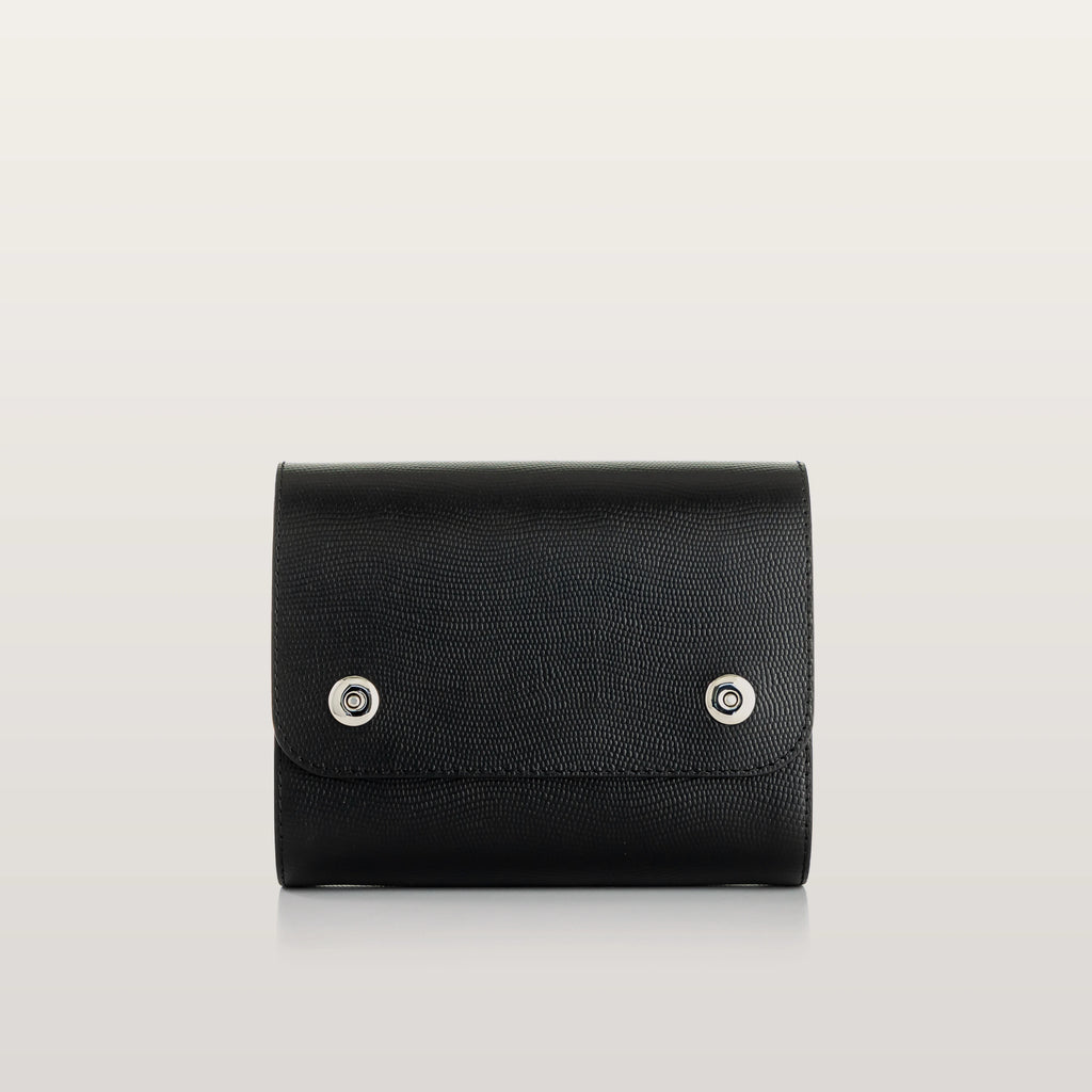 Black leather bag with silver buttons on a light gray background