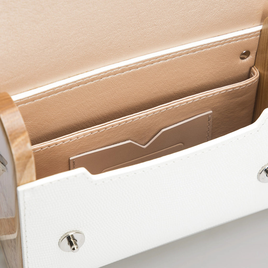 Close-up of a beige leather wallet with white interior on a light gray background